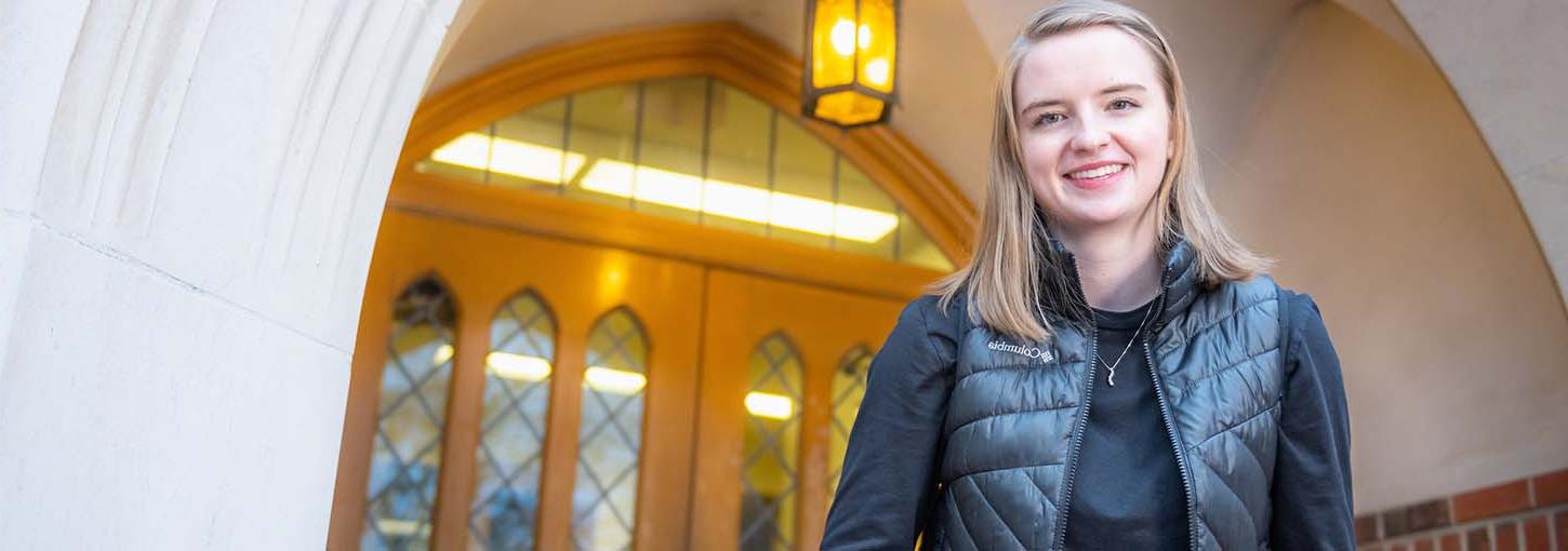 Grace Meyer stands in front of a door